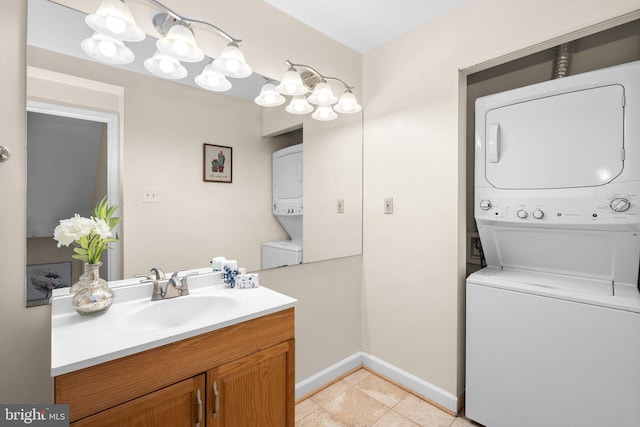 bathroom featuring stacked washer and dryer, baseboards, tile patterned flooring, and vanity