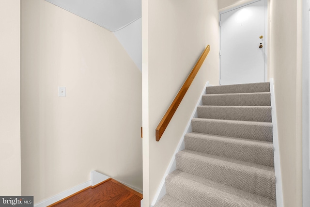 stairway with baseboards and wood finished floors