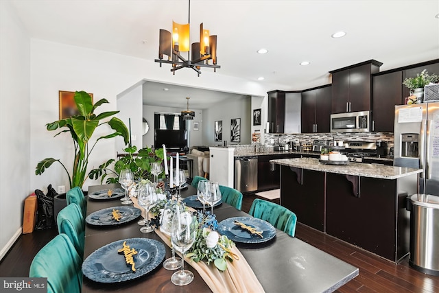 dining area featuring recessed lighting, an inviting chandelier, and dark wood finished floors