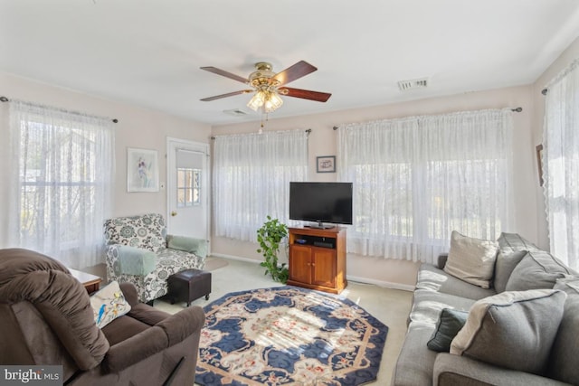 carpeted living area with plenty of natural light, visible vents, baseboards, and a ceiling fan