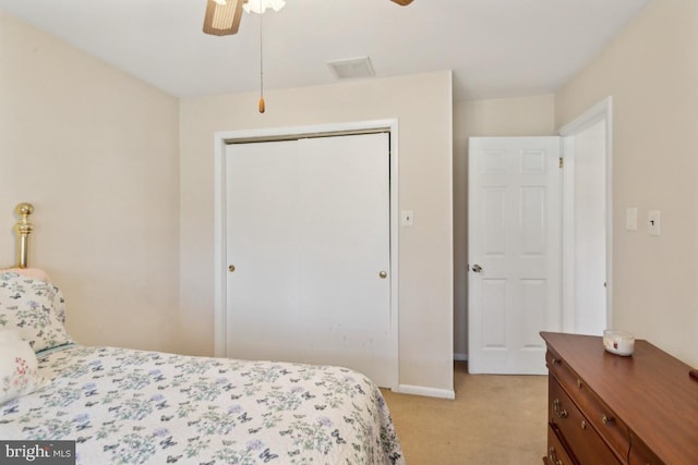 bedroom featuring a closet, baseboards, a ceiling fan, visible vents, and light colored carpet