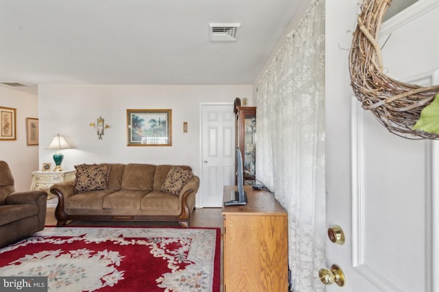 living area with visible vents and wood finished floors