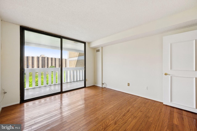 6101 Edsall Rd Unit 1408, Alexandria, VA 22304 - unfurnished room with visible vents, a textured ceiling, floor to ceiling windows, and wood finished floors