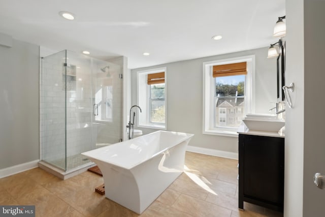 full bathroom featuring a stall shower, vanity, and baseboards