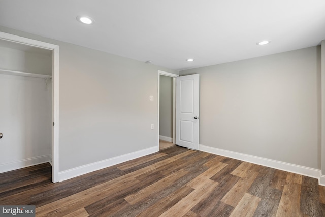 unfurnished bedroom with a closet, recessed lighting, baseboards, and wood finished floors