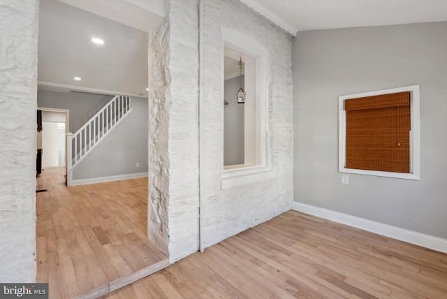empty room featuring wood finished floors, recessed lighting, baseboards, and stairway