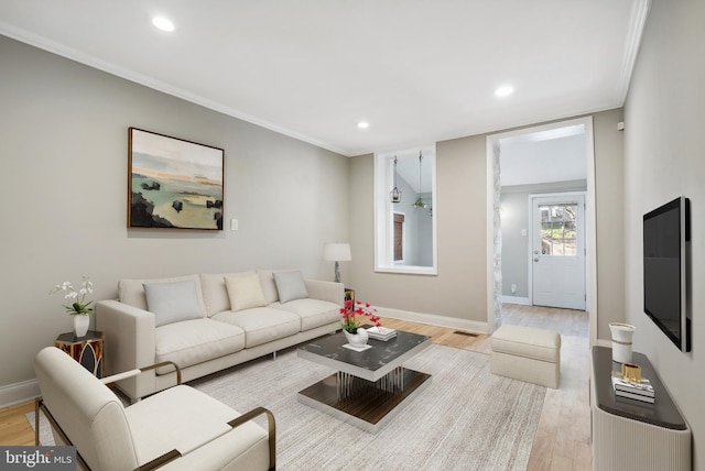 living room with ornamental molding, baseboards, recessed lighting, and light wood-style floors