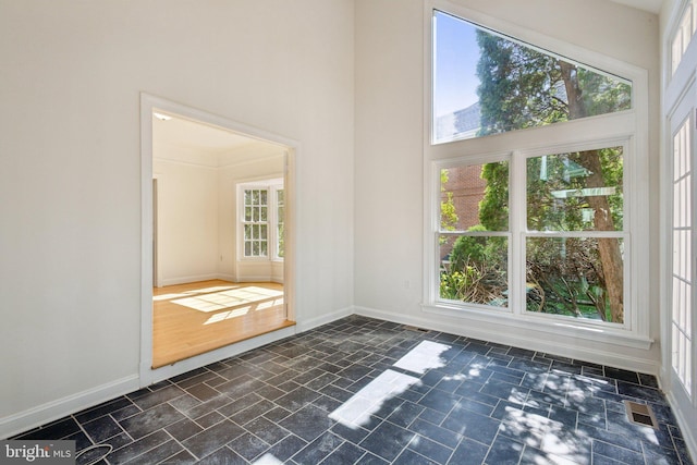 9313 Braymore Cir, Fairfax Station, VA 22039 - empty room featuring stone finish flooring, baseboards, a towering ceiling, and visible vents
