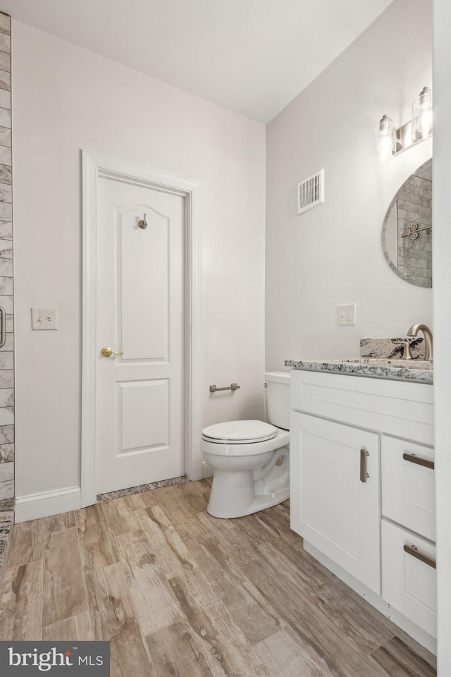 9313 Braymore Cir, Fairfax Station, VA 22039 - bathroom featuring a tile shower, toilet, visible vents, wood finished floors, and vanity