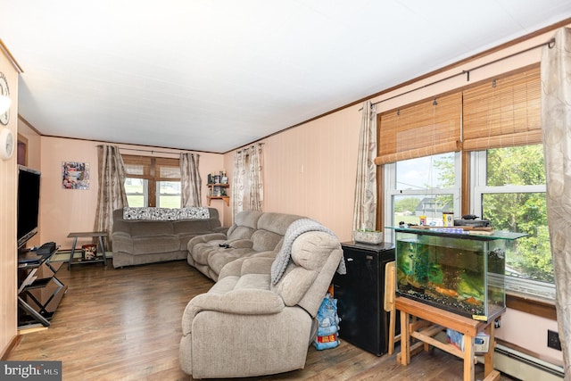 living area with crown molding, a baseboard heating unit, wood finished floors, and baseboard heating