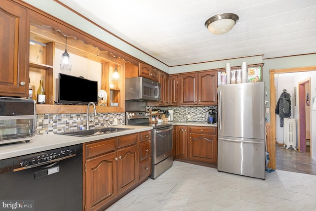 kitchen featuring radiator, marble finish floor, light countertops, a sink, and appliances with stainless steel finishes