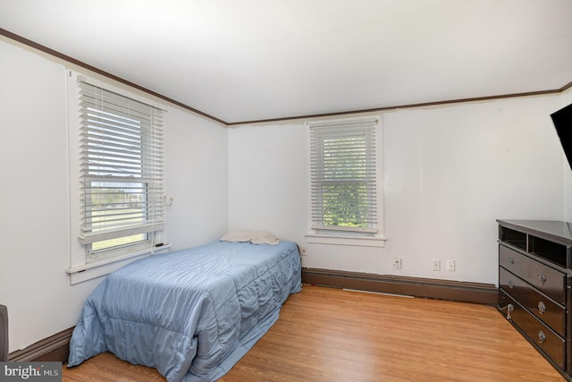 bedroom with wood finished floors and baseboard heating