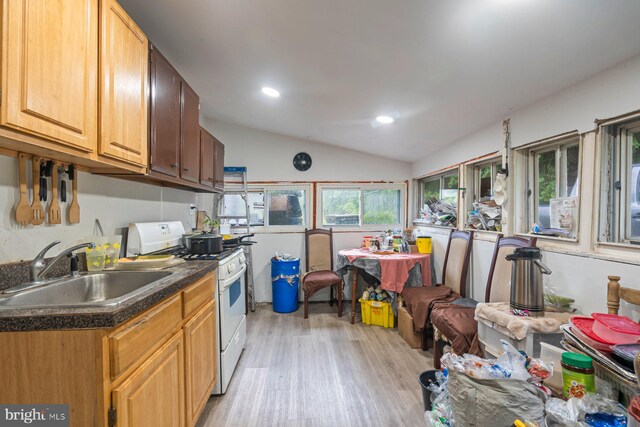 7020 Parsons Ln, Port Norris, NJ 08349 - kitchen featuring white range with gas stovetop, a sink, light wood finished floors, dark countertops, and vaulted ceiling