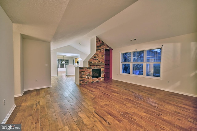 24 Assawoman Ave, Ocean View, DE 19970 - unfurnished living room with vaulted ceiling, dark wood finished floors, visible vents, and a fireplace
