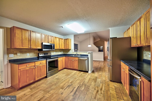 kitchen with appliances with stainless steel finishes, light wood-type flooring, a sink, a peninsula, and wine cooler