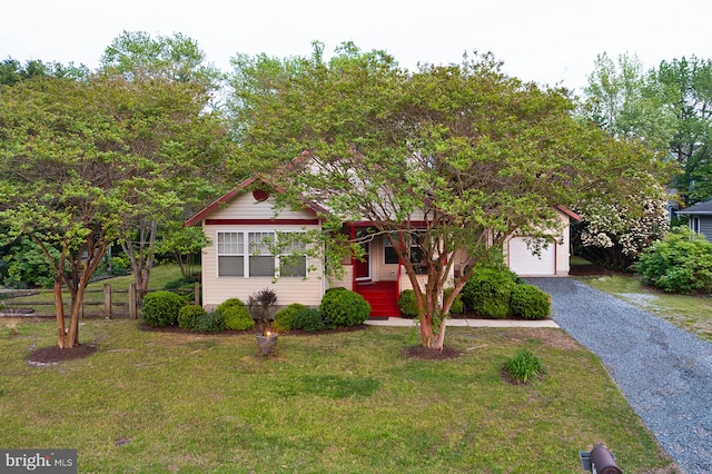 obstructed view of property with a garage, fence, driveway, and a front yard