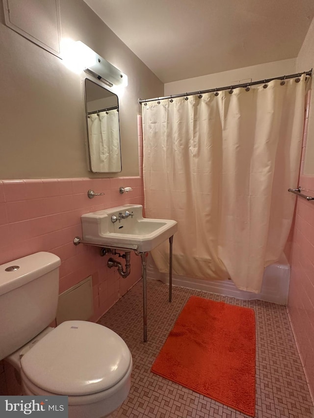 bathroom with a sink, tile walls, and tile patterned floors