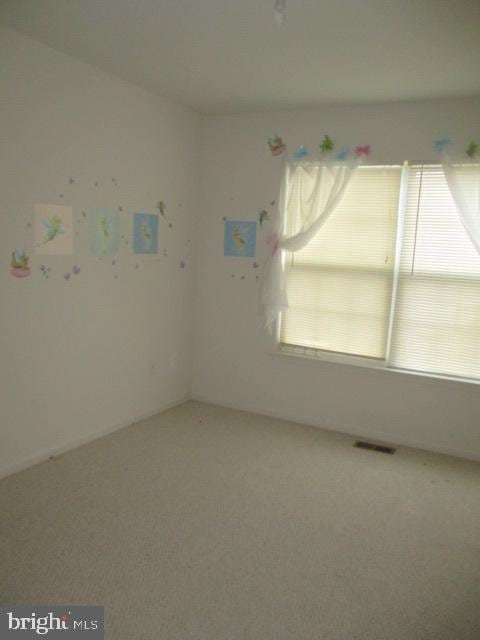 unfurnished room featuring visible vents and carpet flooring
