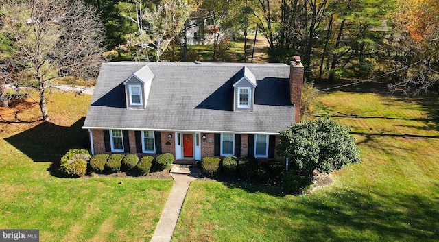 cape cod-style house featuring a shingled roof, brick siding, a chimney, and a front yard