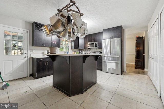 7303 Westwind Ct, Bowie, MD 20715 - kitchen featuring a kitchen breakfast bar, light tile patterned floors, a sink, appliances with stainless steel finishes, and light countertops