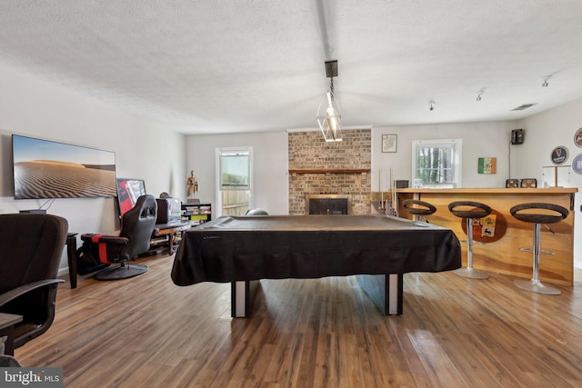 7303 Westwind Ct, Bowie, MD 20715 - recreation room with wood finished floors, a textured ceiling, a fireplace, and pool table