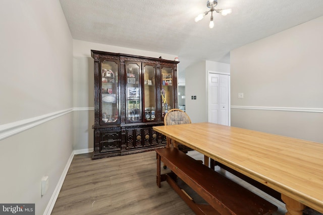 7303 Westwind Ct, Bowie, MD 20715 - dining room with a textured ceiling, wood finished floors, and baseboards