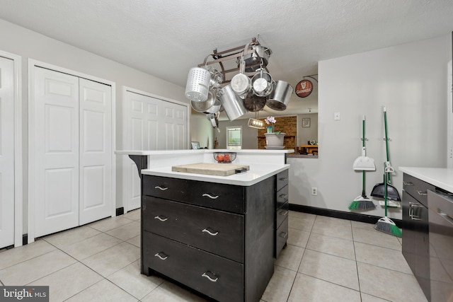 7303 Westwind Ct, Bowie, MD 20715 - kitchen featuring light tile patterned floors, dishwashing machine, a kitchen island, and light countertops