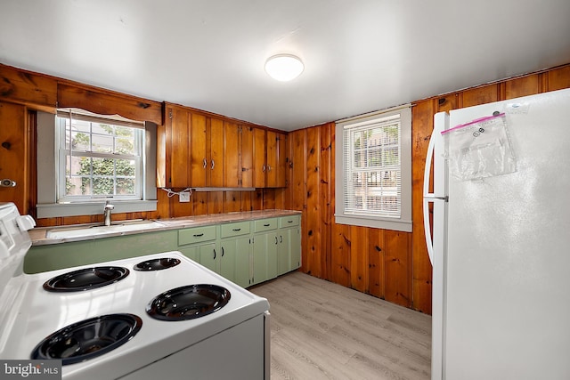 10 34th St, Ocean City, MD 21842 - kitchen featuring a sink, white appliances, green cabinets, wood walls, and light wood-style flooring
