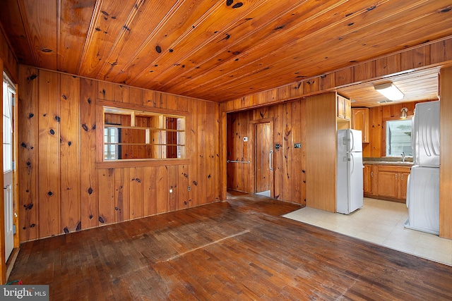 10 34th St, Ocean City, MD 21842 - unfurnished living room featuring wooden walls, light wood-type flooring, a sink, and wood ceiling