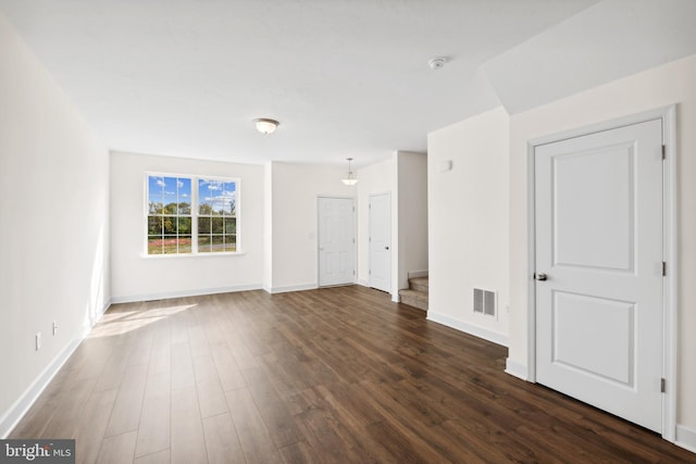 empty room with baseboards, dark wood finished floors, and visible vents