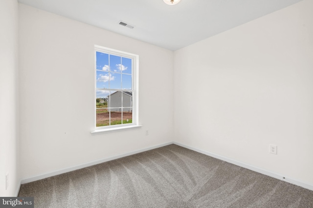 spare room with baseboards, carpet, and visible vents