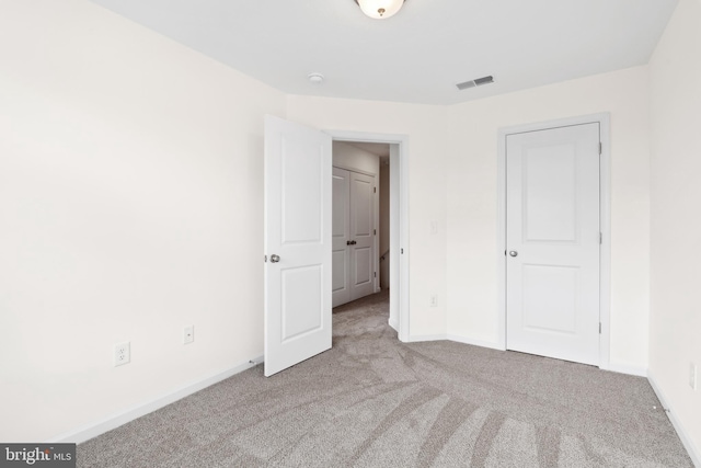 unfurnished bedroom featuring carpet flooring, baseboards, and visible vents