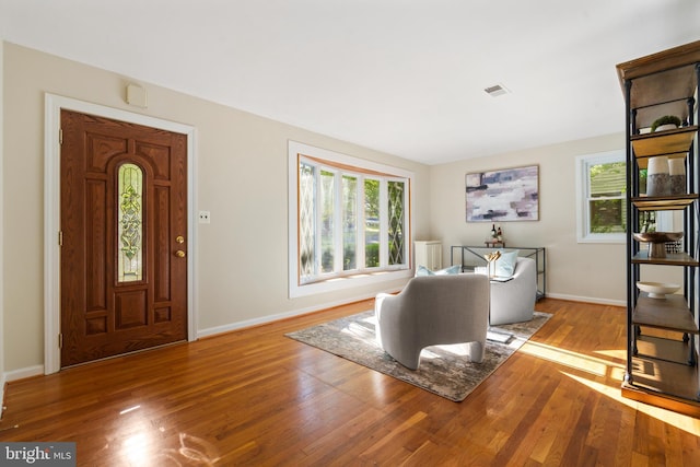 entryway featuring baseboards, visible vents, and wood finished floors