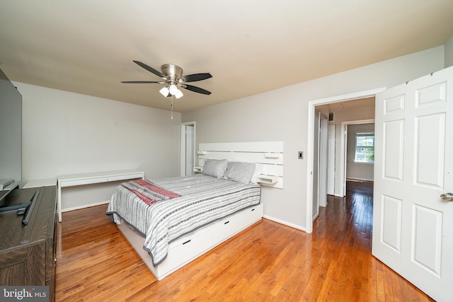 bedroom featuring baseboards, a ceiling fan, and light wood-style flooring