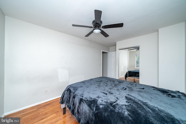 bedroom with baseboards, light wood finished floors, and ceiling fan