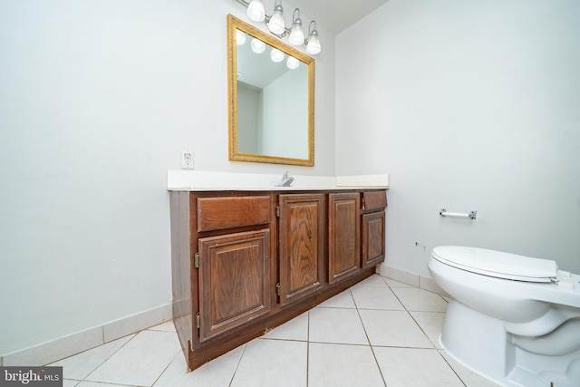 bathroom featuring toilet, tile patterned floors, baseboards, and vanity