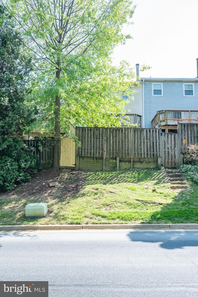 view of yard featuring an outdoor structure, fence, and a storage shed