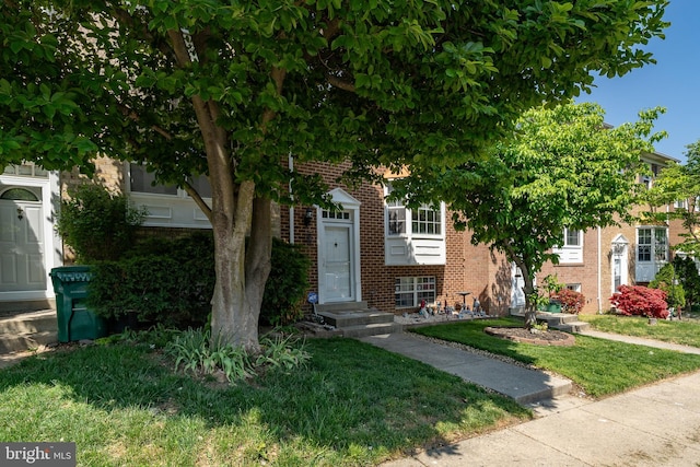 view of front of home featuring brick siding and a front lawn