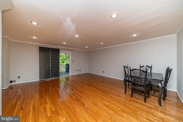 unfurnished dining area with baseboards, ornamental molding, recessed lighting, and wood finished floors