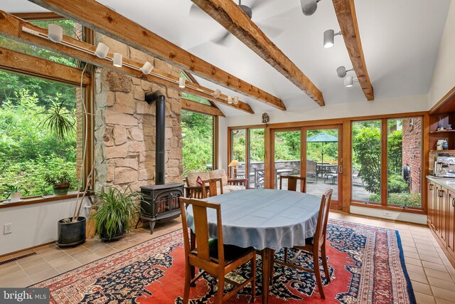 552 Brookwood Rd, Wayne, PA 19087 - dining space featuring a wood stove, light tile patterned floors, beam ceiling, and plenty of natural light