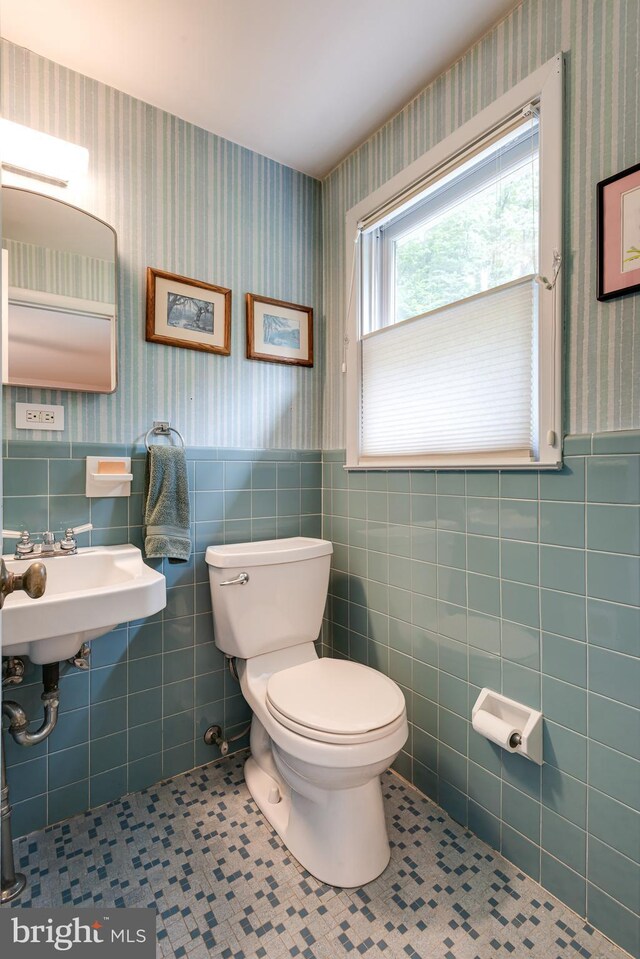552 Brookwood Rd, Wayne, PA 19087 - bathroom featuring wallpapered walls, wainscoting, tile patterned flooring, and tile walls