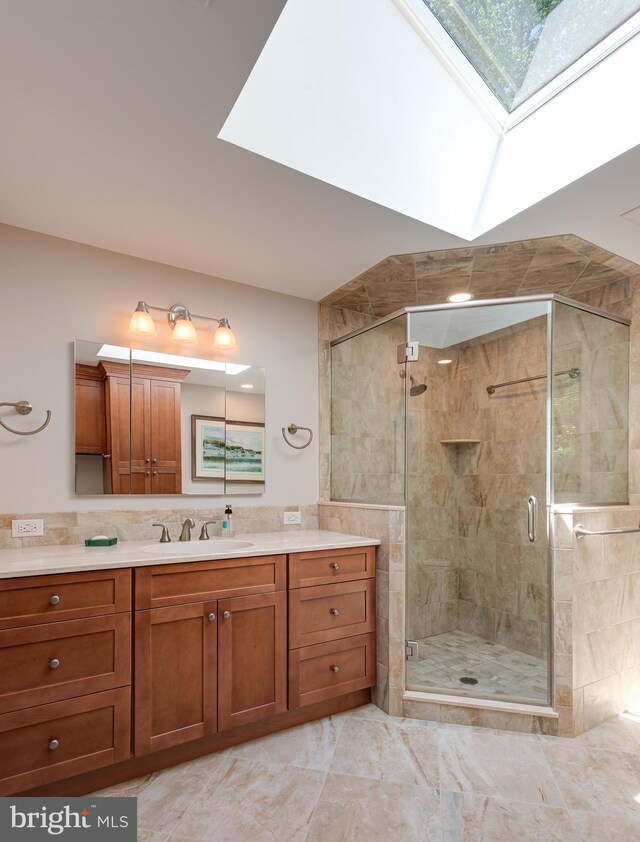 552 Brookwood Rd, Wayne, PA 19087 - full bathroom featuring a skylight, vanity, a stall shower, and marble look tiles