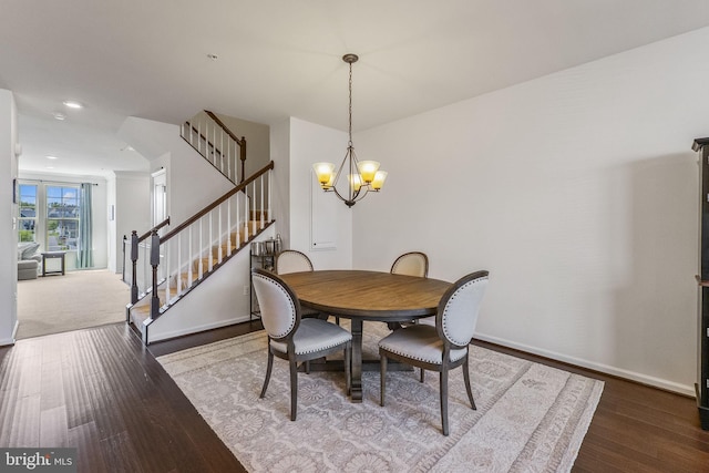 dining room with stairs, baseboards, an inviting chandelier, and wood finished floors