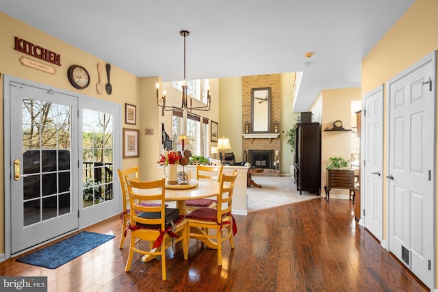 109 Aulee Ct, Winchester, VA 22602 - dining room featuring a fireplace, wood finished floors, an inviting chandelier, and a healthy amount of sunlight