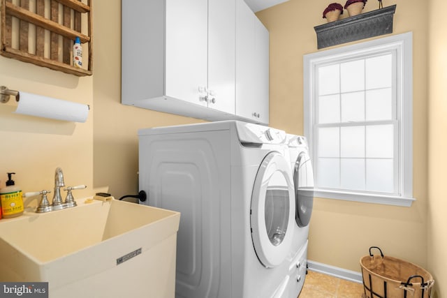 109 Aulee Ct, Winchester, VA 22602 - washroom featuring washer and clothes dryer, light tile patterned floors, a sink, baseboards, and cabinet space