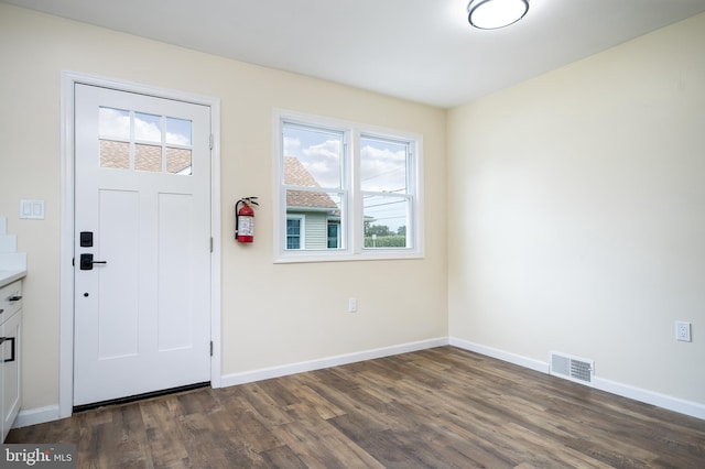 foyer entrance with dark wood-style flooring, baseboards, and visible vents