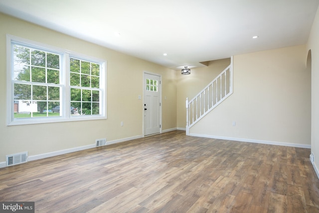 entryway with visible vents, baseboards, recessed lighting, wood finished floors, and stairs