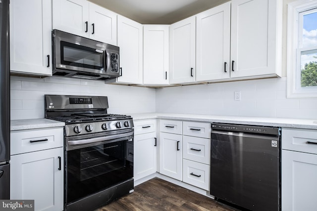 kitchen featuring dark wood finished floors, tasteful backsplash, white cabinets, light countertops, and stainless steel appliances