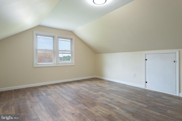bonus room with wood finished floors, baseboards, and vaulted ceiling