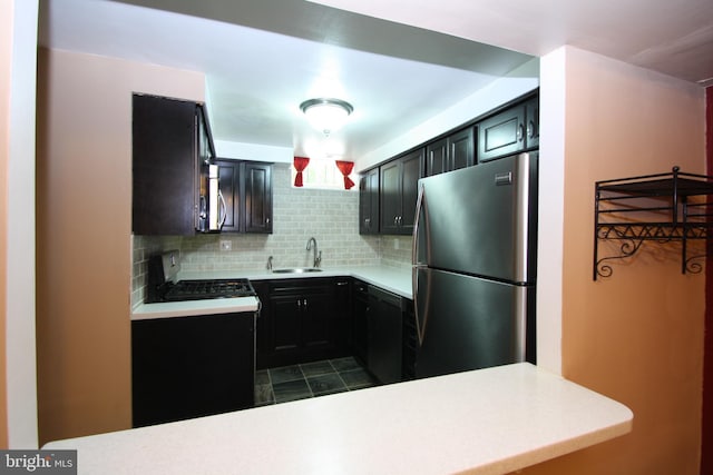 506 S 11th St Unit 33, Philadelphia, PA 19147 - kitchen with appliances with stainless steel finishes, light countertops, a sink, dark cabinetry, and decorative backsplash